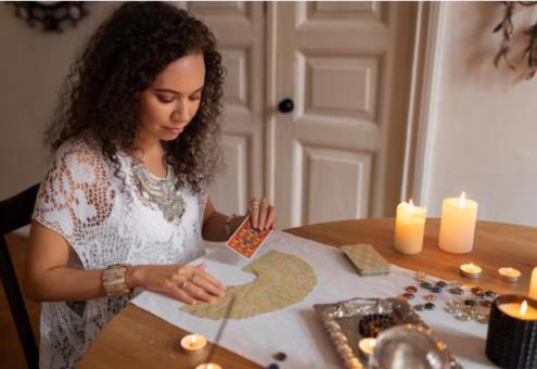 Vrouw met paarse heksenhoed voor een spirituele achtergrond in warme tinten, symbool voor intu&#239;tie, mystiek en innerlijke kracht – perfecte visuele we