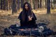 Vrouw met paarse heksenhoed voor een spirituele achtergrond in warme tinten, symbool voor intuïtie, mystiek en innerlijke kracht – perfecte visuele we