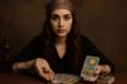 Medium Catharina met tarotkaarten en munten, in Oost-Europese spirituele sfeer, met hoofddoek, rode haren en serene, mystieke uitstraling.